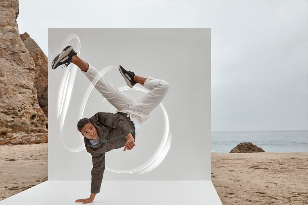 Man in Vionic Walk Max sneakers on a beach with dramatic rock formations